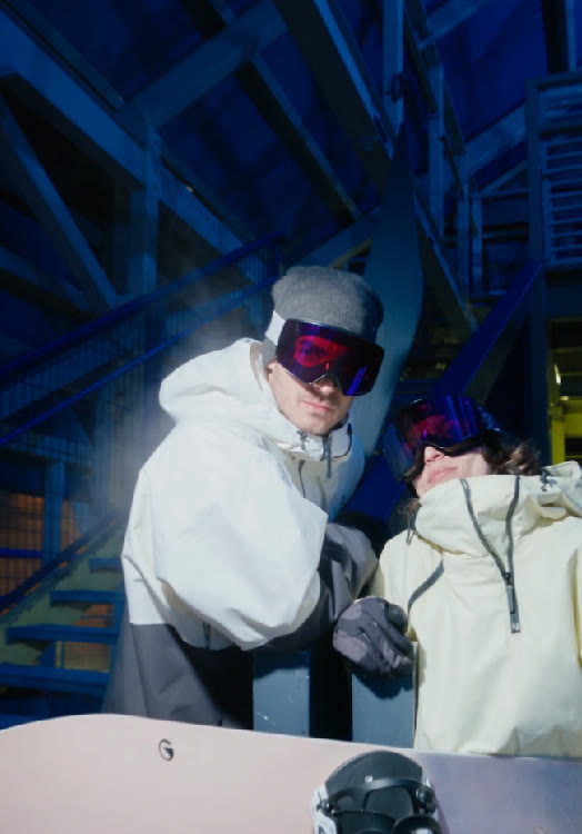 Duo de snowboarders sous un escalier métallique bleu